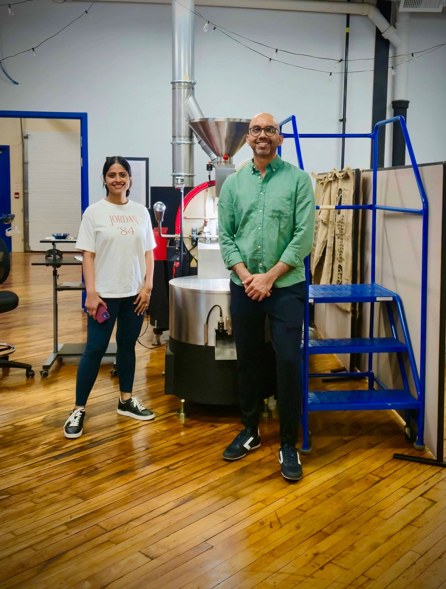 founders of Origin Hill Coffee Roasters, standing beside their roasting setup at KWCC co-roasting space in Toronto.